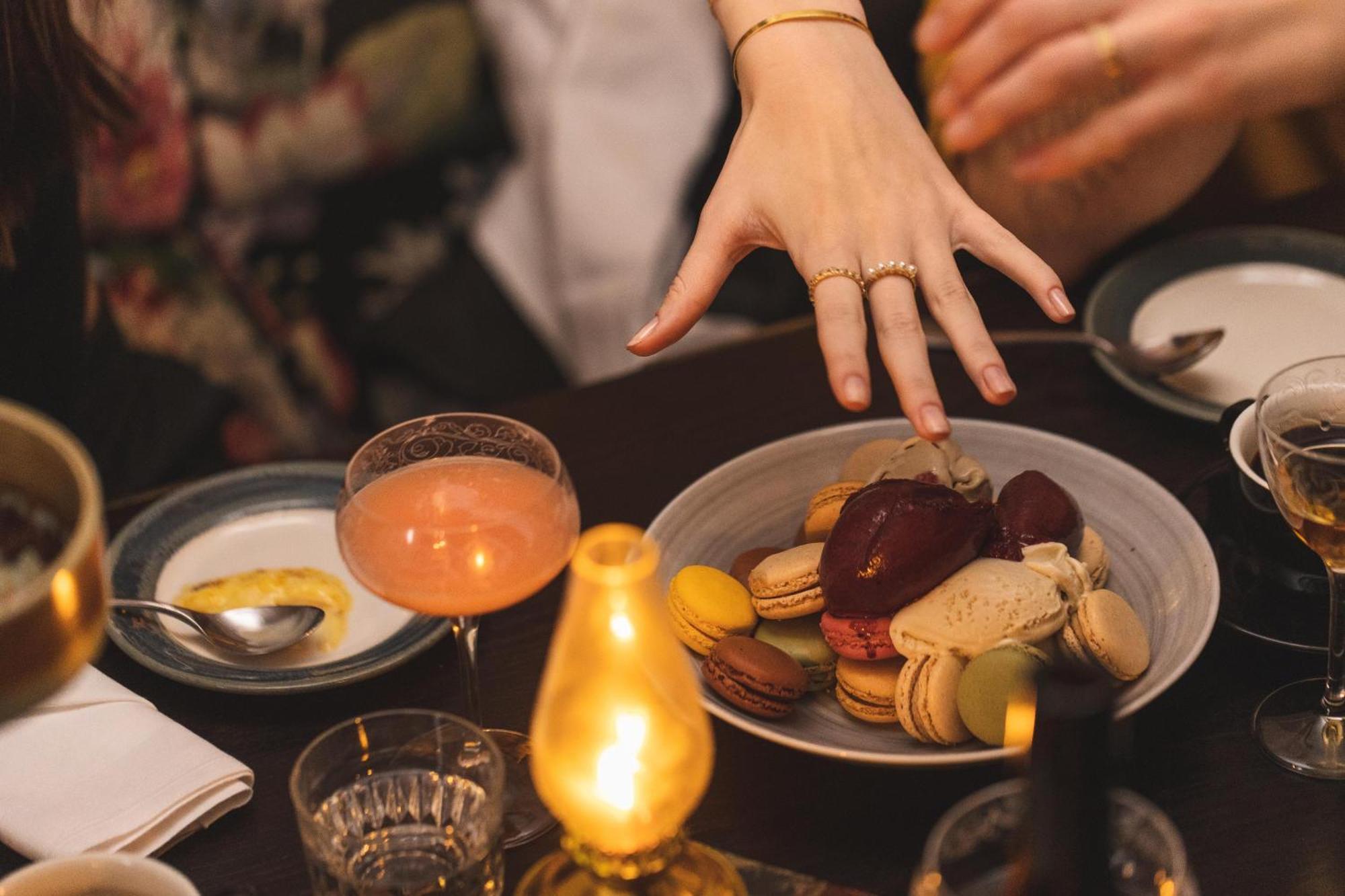 גטבורג Hotel Pigalle מראה חיצוני תמונה A woman's hand reaches for a plate of macarons